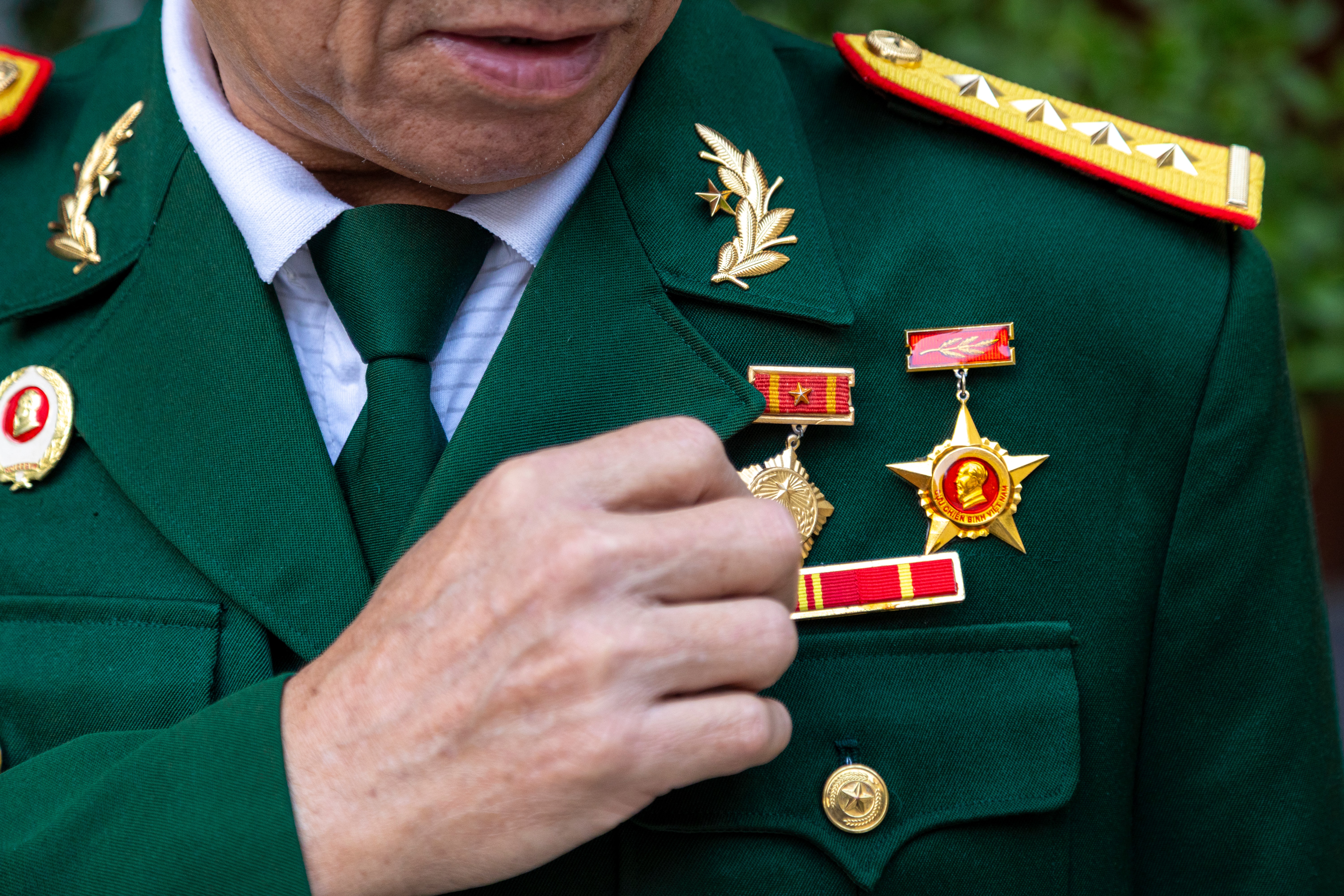 Ông Lê Văn Len (72 tuổi) chỉnh lại quân phục chuẩn bị cho ngày kỷ niệm. Những tấm huân chương ghi dấu quá trình phục vụ quân ngũ của người lính lái xe năm xưa. (Ảnh: Trà My)