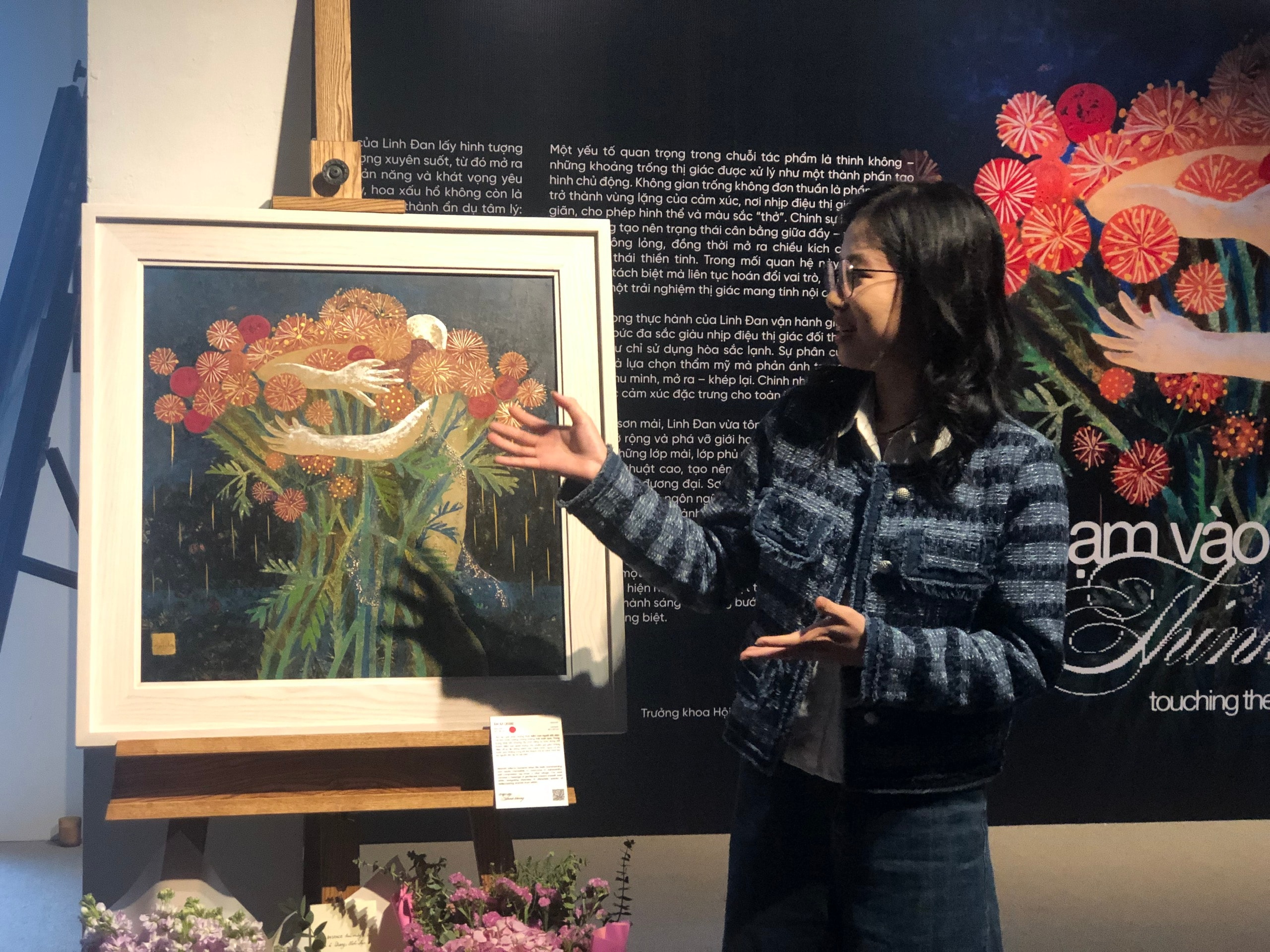 Nữ họa sĩ giới thiệu về ý nghĩa của bức . (Ảnh: Đông Chí)