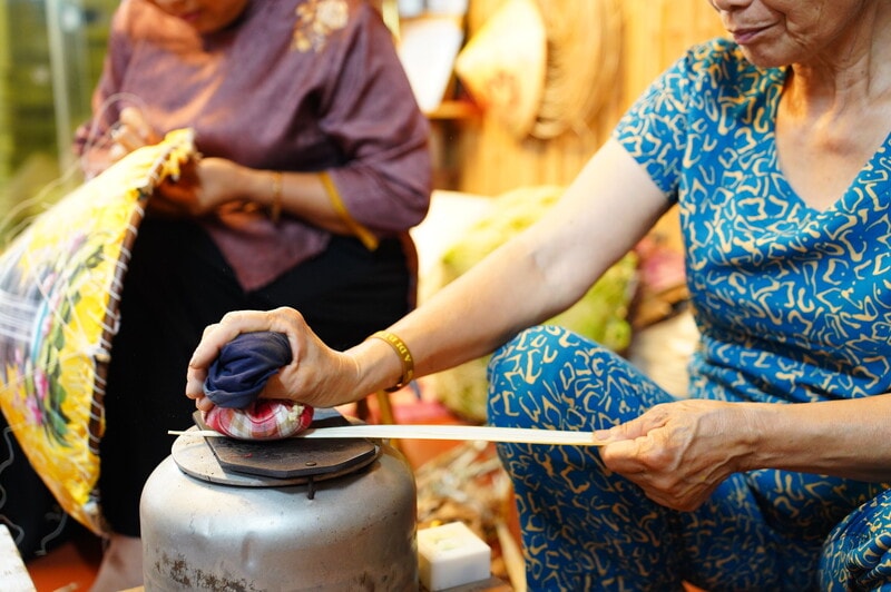 Sau khi rẽ, lá được là trên bọc giẻ đặt trên lưỡi cày hơ nóng. Công đoạn này giúp mặt lá phẳng ra, giữ màu trắng ngà tự nhiên, giảm cong vênh và tạo độ dẻo để khi lên nón, từng lớp lá nằm khít mà không bị gợn.