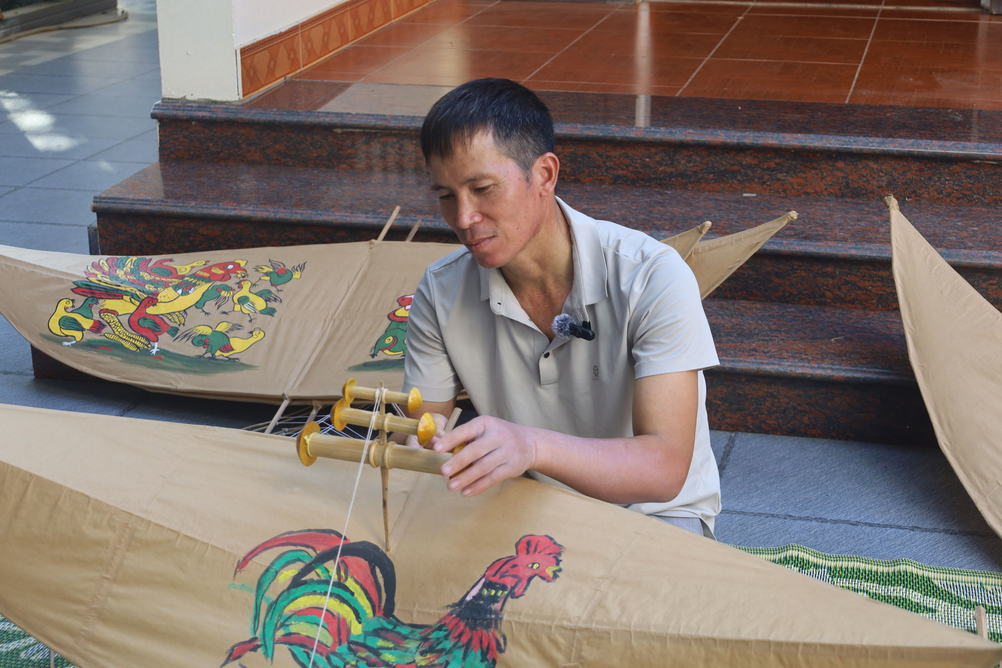 Nghệ nhân diều sáo Nguyễn Văn Quyết bên những cánh diều đang dần được hoàn thiện.
